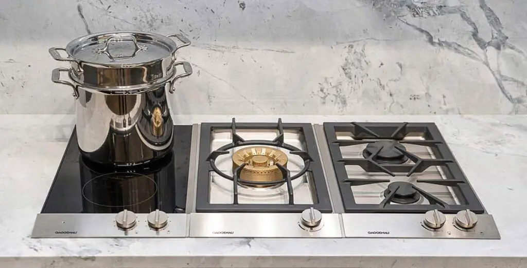 cooktop hibrido com 3 queimadores a gás e 2 de indução e uma panela em inox