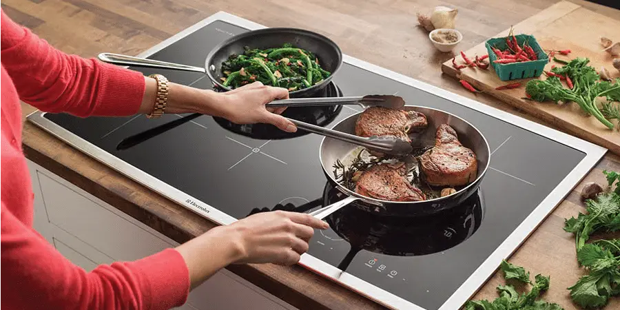 mulher preparando alimentos no cooktop de indução