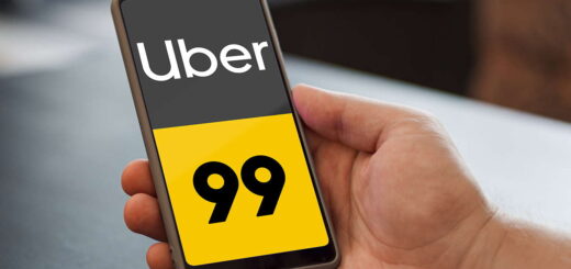 mão masculina segurando celular na tela aparece a logo do Uber e 99