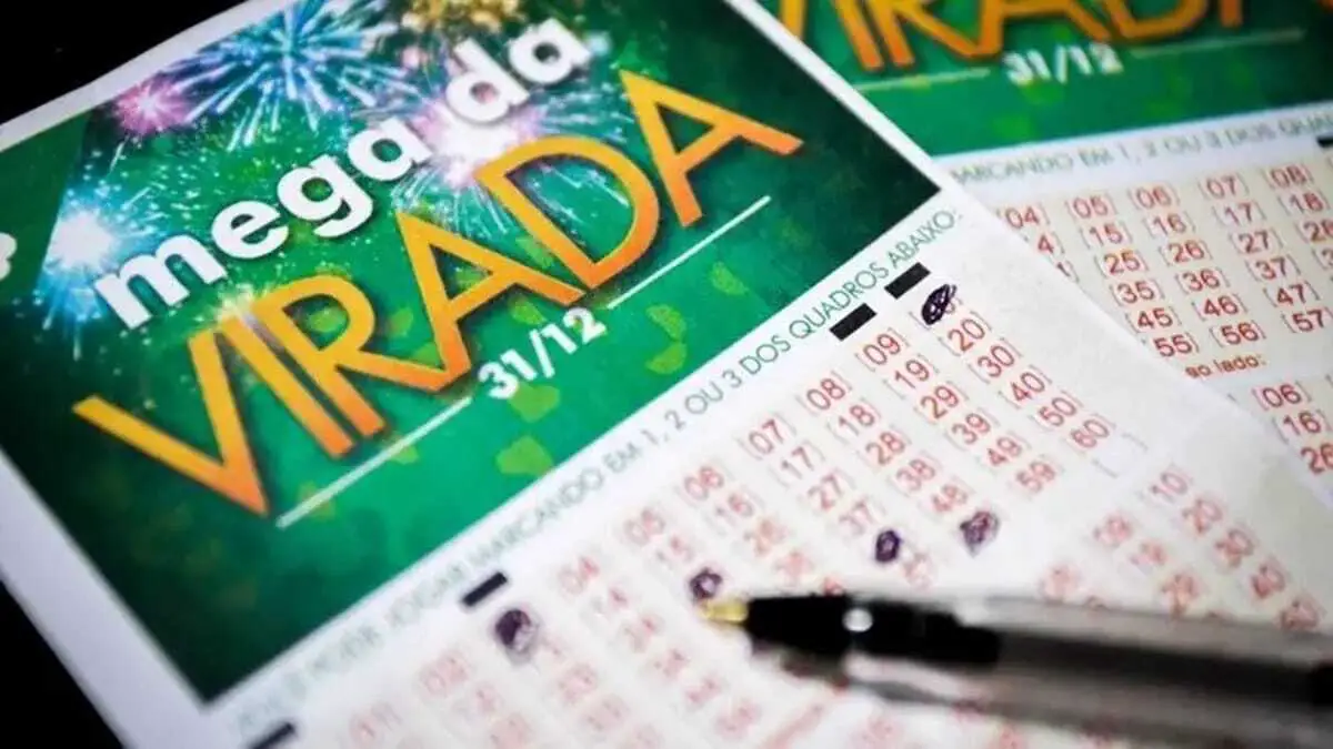 Bilhetes da Mega da Virada preenchidos com caneta sobre superfície de madeira, com logo festivo e números marcados.